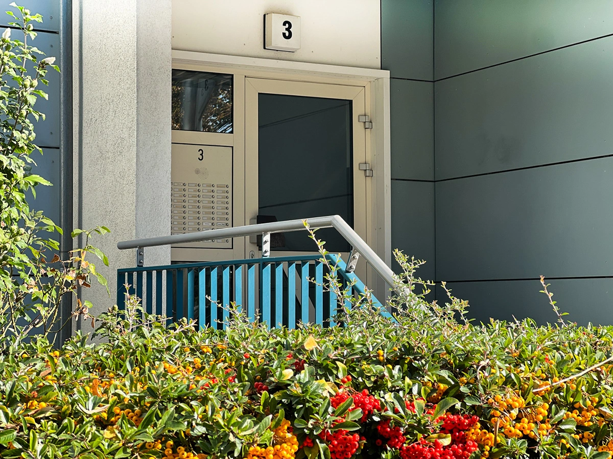 Berlin building entrance detail with facade, railing and greenery